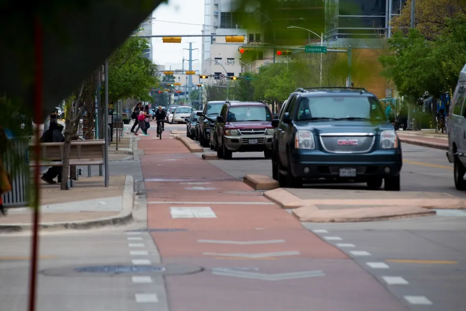 Red painted and curb-protected bike lane in downtown Austin, Texas.